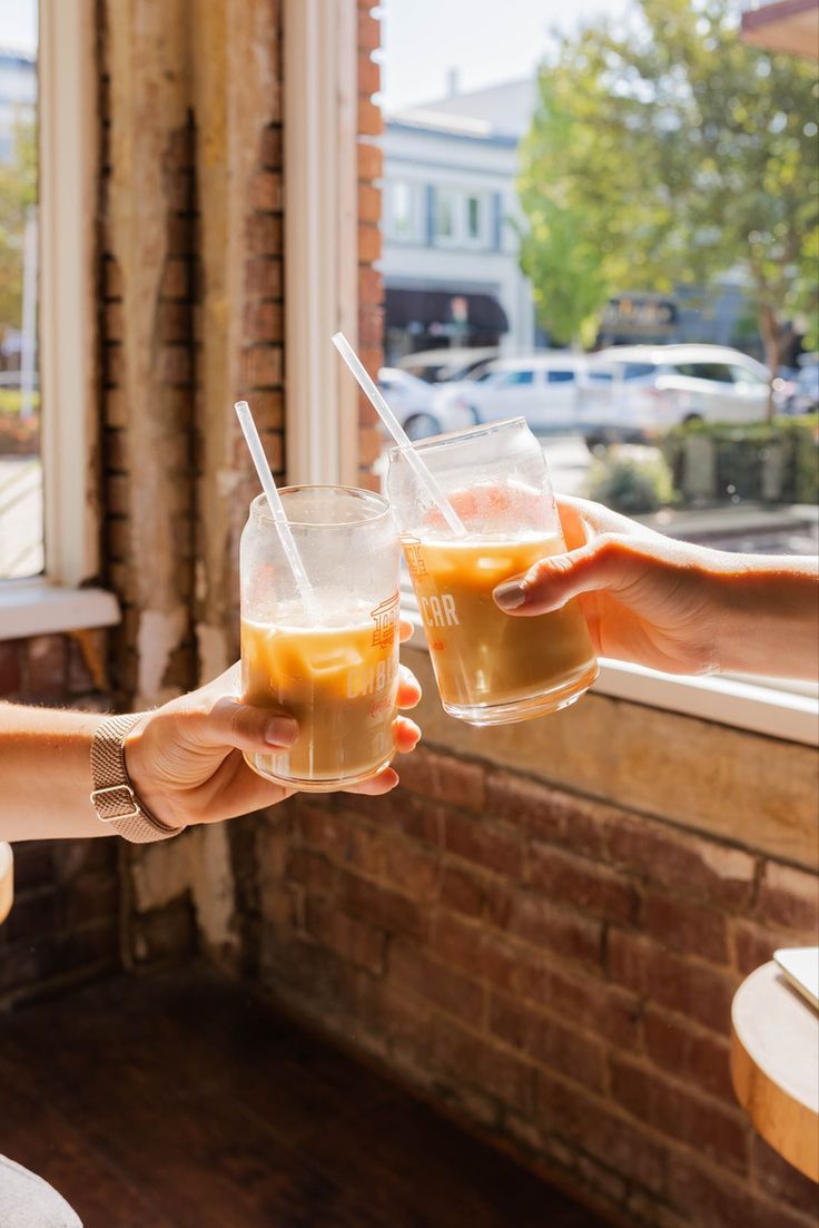 窓辺の光の中で、友人とアイスラテで乾杯
